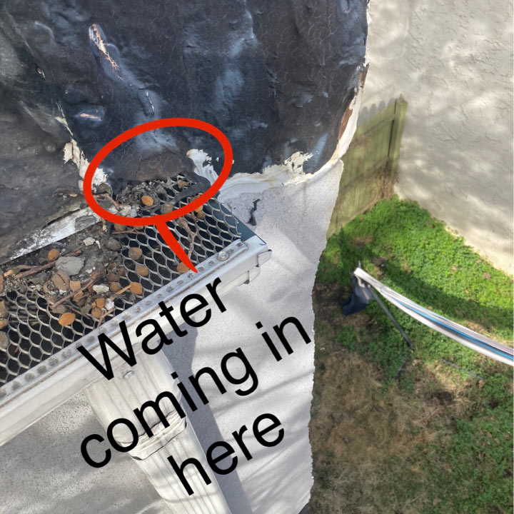 Roof gutter with leaves showing hole where water is causing a leak