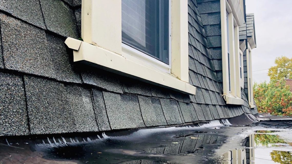 Image of house with water on roof and homeowners wondering what to do when your roof is leaking