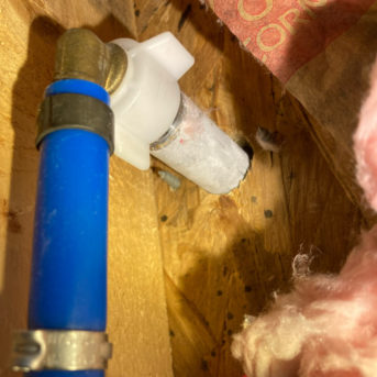 Close up image of a leaky pipe surrounded by insulation and wooden beams as Dr Leaks diagnoses the issue